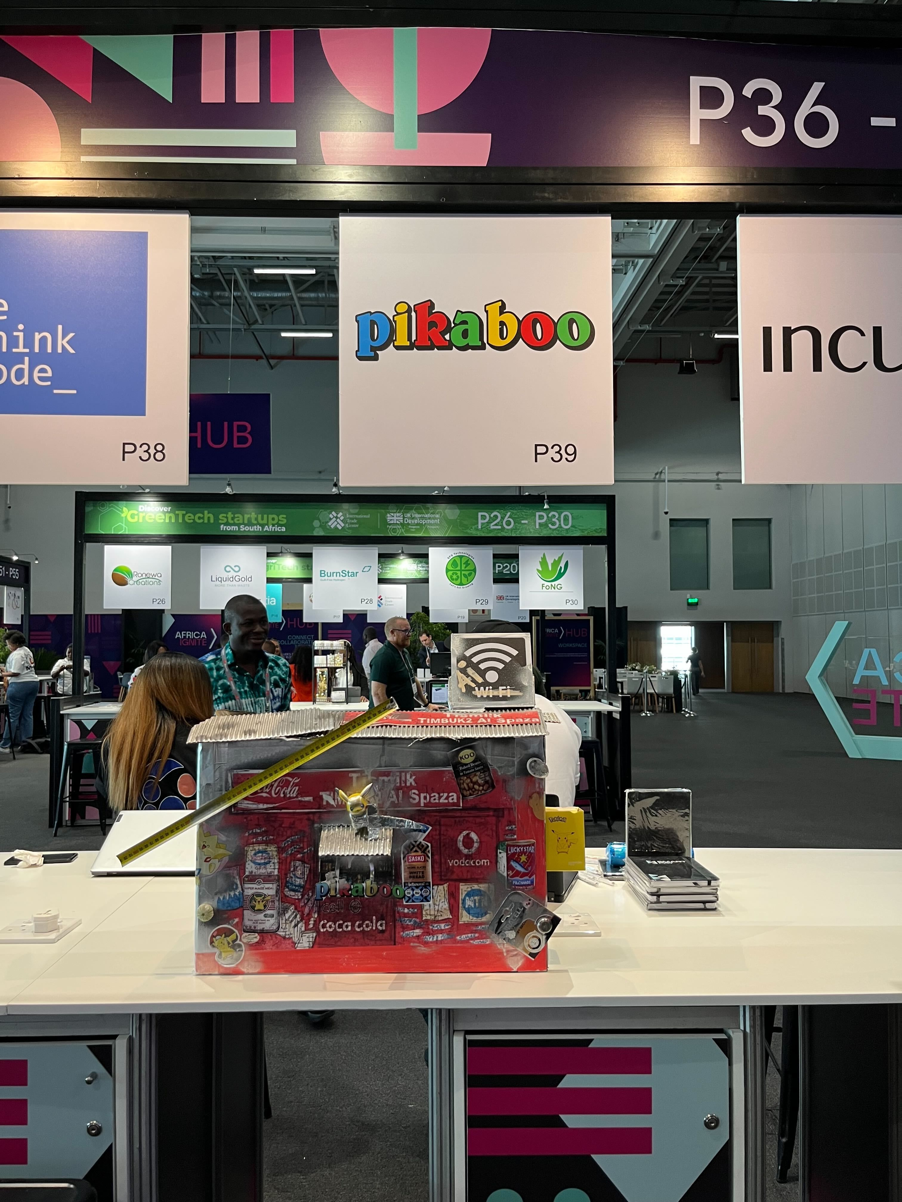 A model spaza shop clad in out-of-home brand ads — the Timbuk2 measurement rig — on the stand at a startup expo